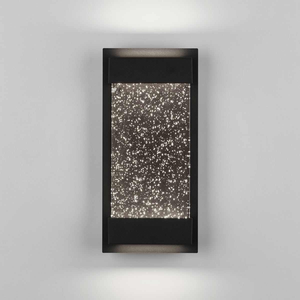 A modern rectangular wall sconce with a black frame and a center panel featuring a pattern of small, illuminated dots resembling a starry night sky. Light glows softly above and below the fixture.