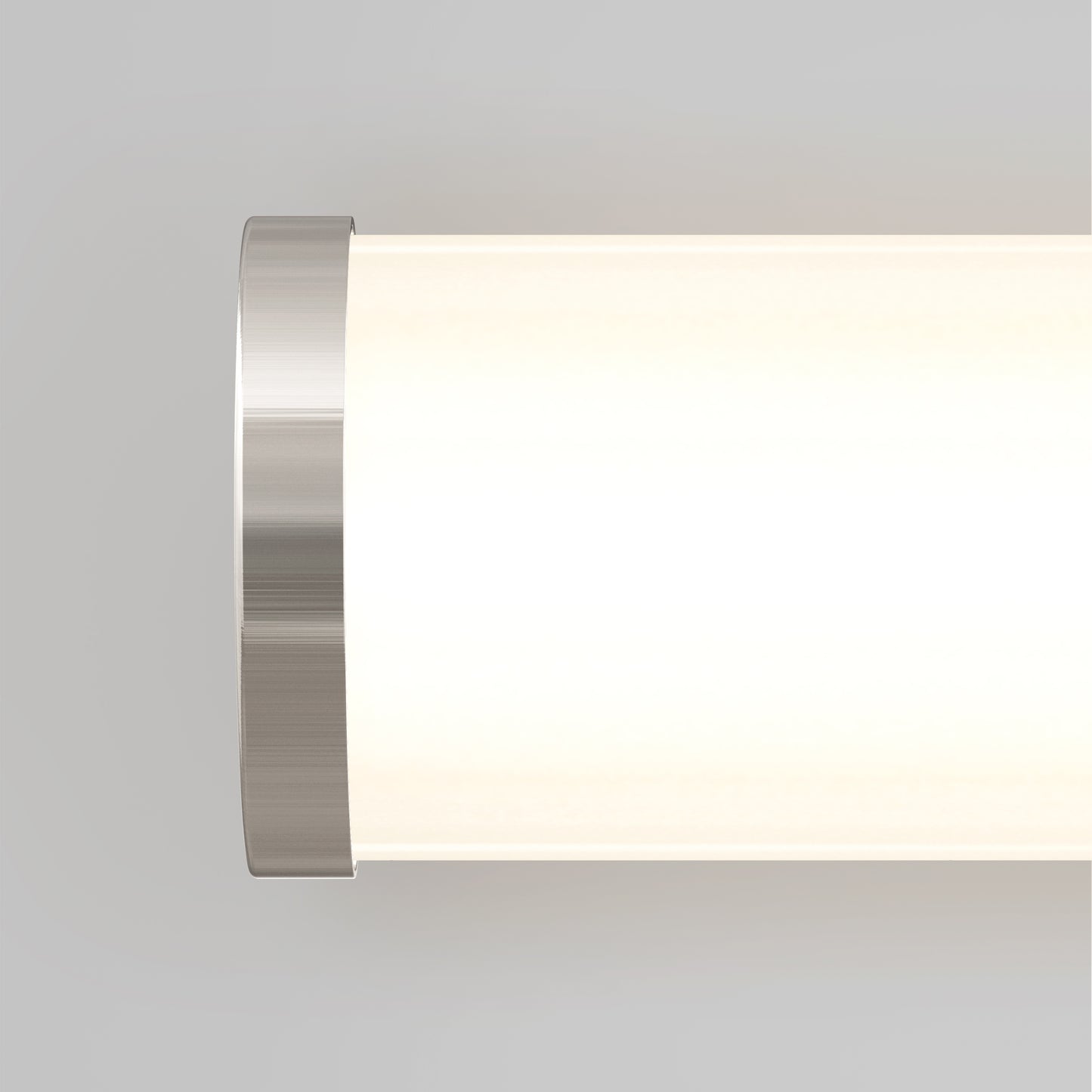 Close-up of the Artika Adina modern bathroom vanity light 3 CCT, featuring a cylindrical shape with a brushed metal end cap and glowing white diffuser, set against a plain light gray background.