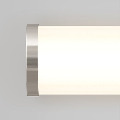 Close-up of the Artika Adina modern bathroom vanity light 3 CCT, featuring a cylindrical shape with a brushed metal end cap and glowing white diffuser, set against a plain light gray background.