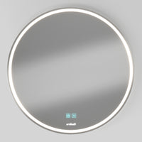 The Artika Mateo 28 in. LED mirror features a round, wall-mounted design with an LED light ring, touch controls on the lower surface, and built-in defogger. Shown against a plain light grey wall.