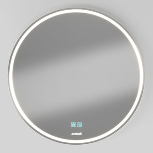 The Artika Mateo 28 in. LED mirror features a round, wall-mounted design with an LED light ring, touch controls on the lower surface, and built-in defogger. Shown against a plain light grey wall.