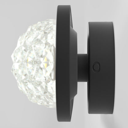 The Artika Carat LED contemporary bathroom vanity light 3 CCT features a faceted, crystal-like glass cover and a matte black circular base, ideal for modern spaces.