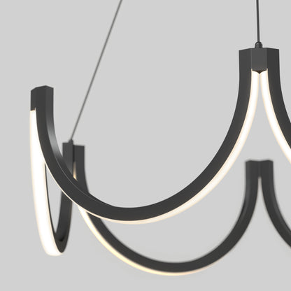 A close-up of the Artika Adelia LED pendant light 5 CCT, a modern, minimalist chandelier with three black curved arms and integrated LED lights, suspended against a plain light gray background.