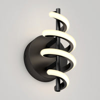 The Artika Chorus LED Wall Light features a black circular base and vertical rod wrapped with two spiral LED tubes, emitting a soft white glow, shown mounted on a light gray wall.