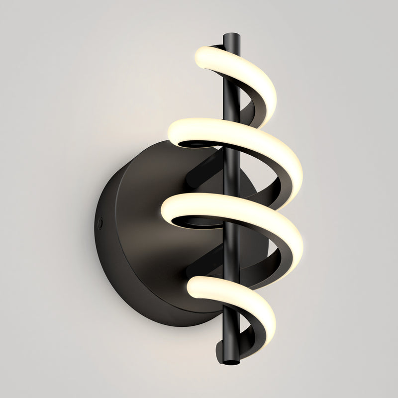 The Artika Chorus LED Wall Light features a black circular base and vertical rod wrapped with two spiral LED tubes, emitting a soft white glow, shown mounted on a light gray wall.