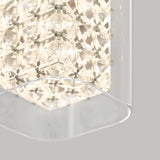 A close-up of a modern, geometric light fixture with intricate, lattice-like patterns and bright, white glowing lights, surrounded by a clear, curved glass or acrylic panel against a neutral background.