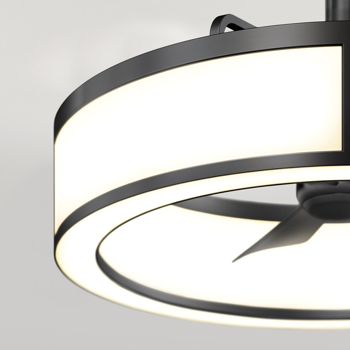 Close-up view of a modern ceiling fan with a circular LED light fixture, featuring a black metal frame and sleek, minimalist design against a neutral, light background.