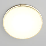 A round, modern ceiling light fixture with a glowing white center and a thin gold outer rim, mounted on a smooth, light gray ceiling.