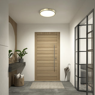 Modern entryway with a light wood door, Delray 15.7 in. LED modern flush mount light by Artika, gray rug, glass-panel wall, floating shelf with potted plants, decorative basket with pillows, and an umbrella in the corner.