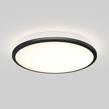 The Artika Vera 13 in. LED modern flush mount light features a round design with a black outer rim and white glowing center, seamlessly mounted on a plain white ceiling.