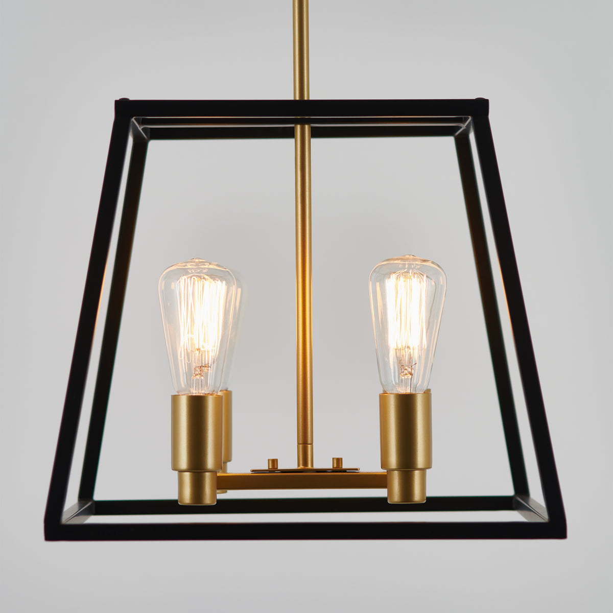 A modern pendant light fixture with two exposed Edison bulbs, gold-colored sockets, and a sleek black geometric frame hanging against a plain light gray background.