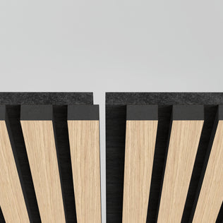 Close-up of two Artika Sonolok sound-absorbing wall panel kits with alternating light and dark wood slats, separated by a slim vertical gap, against a light gray background.