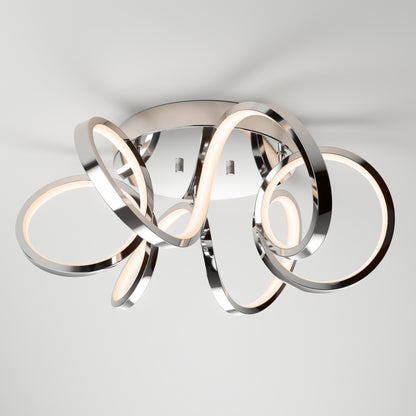 The Artika Swirl Ribbon LED flush mount light features intertwined chrome loops with integrated, dimmable LEDs. Its abstract design enhances any room with a modern, contemporary touch. Mounted on a smooth white ceiling for a sleek finish.