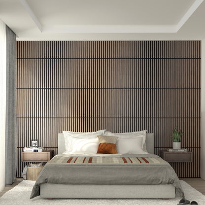 A modern bedroom features an Artika Sonolok 15.5 ft sound-absorbing wall panel kit as a wooden slat accent, a neatly made bed with neutral bedding and brown pillows, matching nightstands with decor, and soft natural window light.