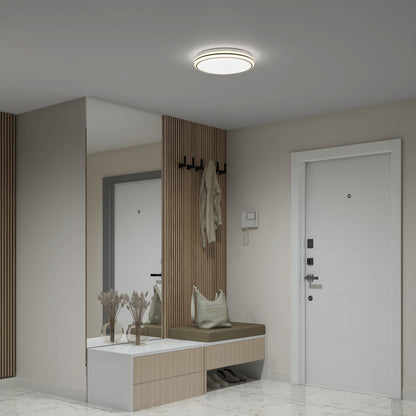 Modern entryway featuring a white door, wall-mounted coat hooks with a jacket, built-in bench with cushions, vertical wood paneling, mirror, minimalist decor, and an Artika Emina 13 in. LED flush mount light (3 CCT, 800 lumens).