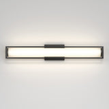 A modern, rectangular wall-mounted light fixture with a frosted glass center and metal frame, emitting a soft, even glow against a plain white wall.