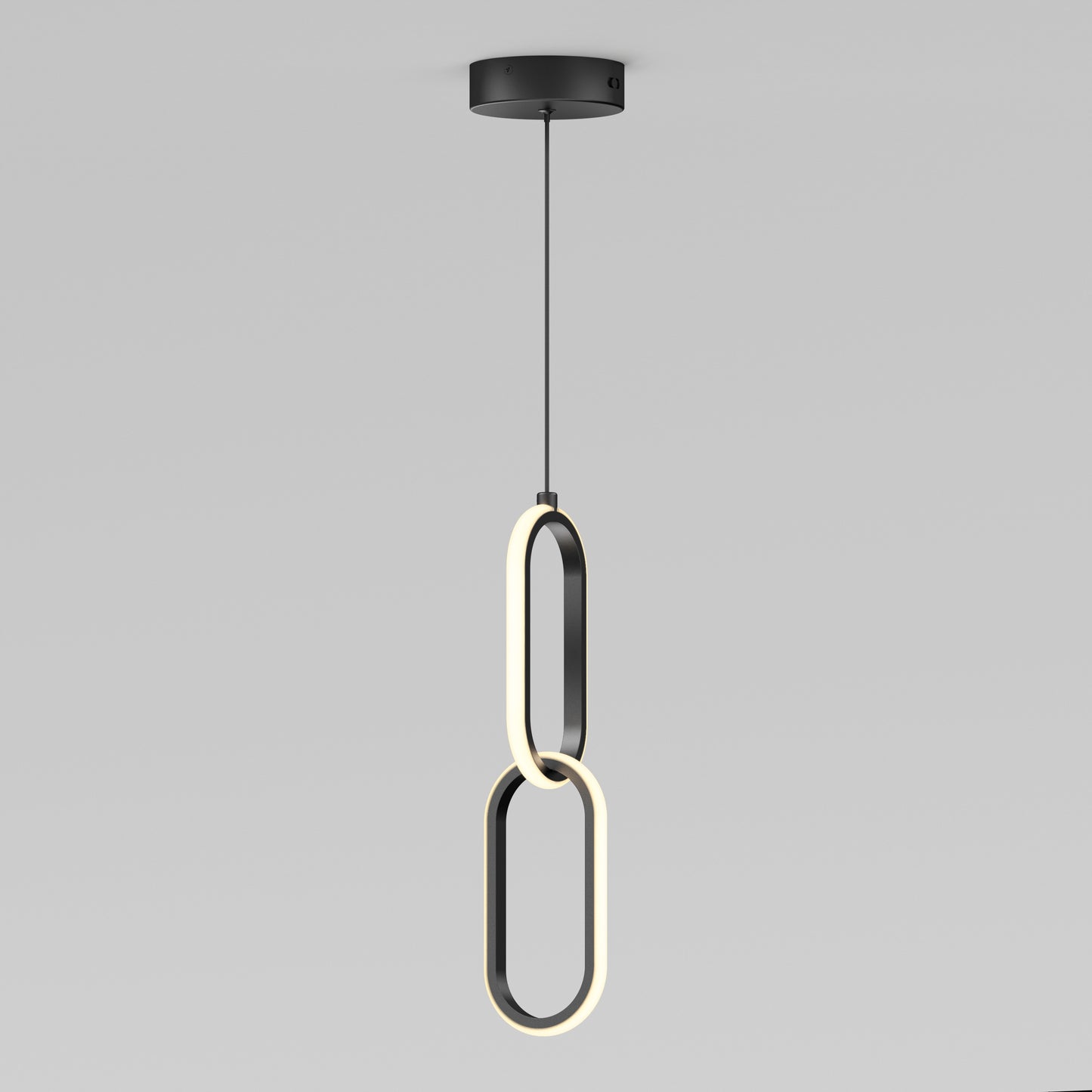 The Artika Catena LED pendant light features two intersecting oval LED rings hanging vertically from a black ceiling mount, showcasing a sleek, modern design. Adjustable to 5 CCTs, its perfect for minimalist interiors.