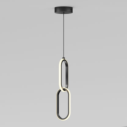 The Artika Catena LED pendant light features two intersecting oval LED rings hanging vertically from a black ceiling mount, showcasing a sleek, modern design. Adjustable to 5 CCTs, its perfect for minimalist interiors.