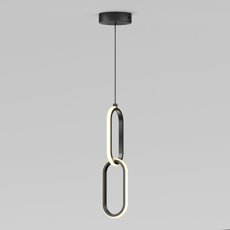 The Artika Catena LED pendant light features two intersecting oval LED rings hanging vertically from a black ceiling mount, showcasing a sleek, modern design. Adjustable to 5 CCTs, its perfect for minimalist interiors.