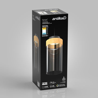 A black rectangular box displays an image of the Hanson 1-light LED pendant 5 CCT with a black cylindrical shade and wooden accent. The Artika brand and technical specs appear in white text on the black packaging.