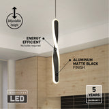 Modern black matte LED pendant light with an abstract twisted design hanging in a kitchen, featuring energy efficiency, adjustable height, integrated LED, and a 5-year warranty.