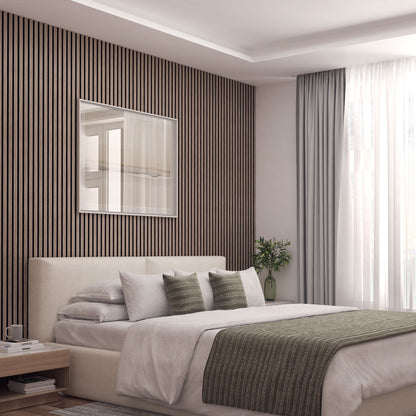 A modern bedroom featuring Artikas Sonolok sound-absorbing wall panel kit, a beige upholstered bed with white and green bedding, a large window with white curtains, a side table with books, and a small plant in a vase.