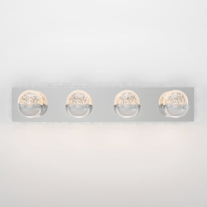 The Artika Oracle LED bathroom vanity light is a modern wall-mounted fixture with a rectangular chrome base and four evenly spaced round lights, each featuring a textured glowing interior.