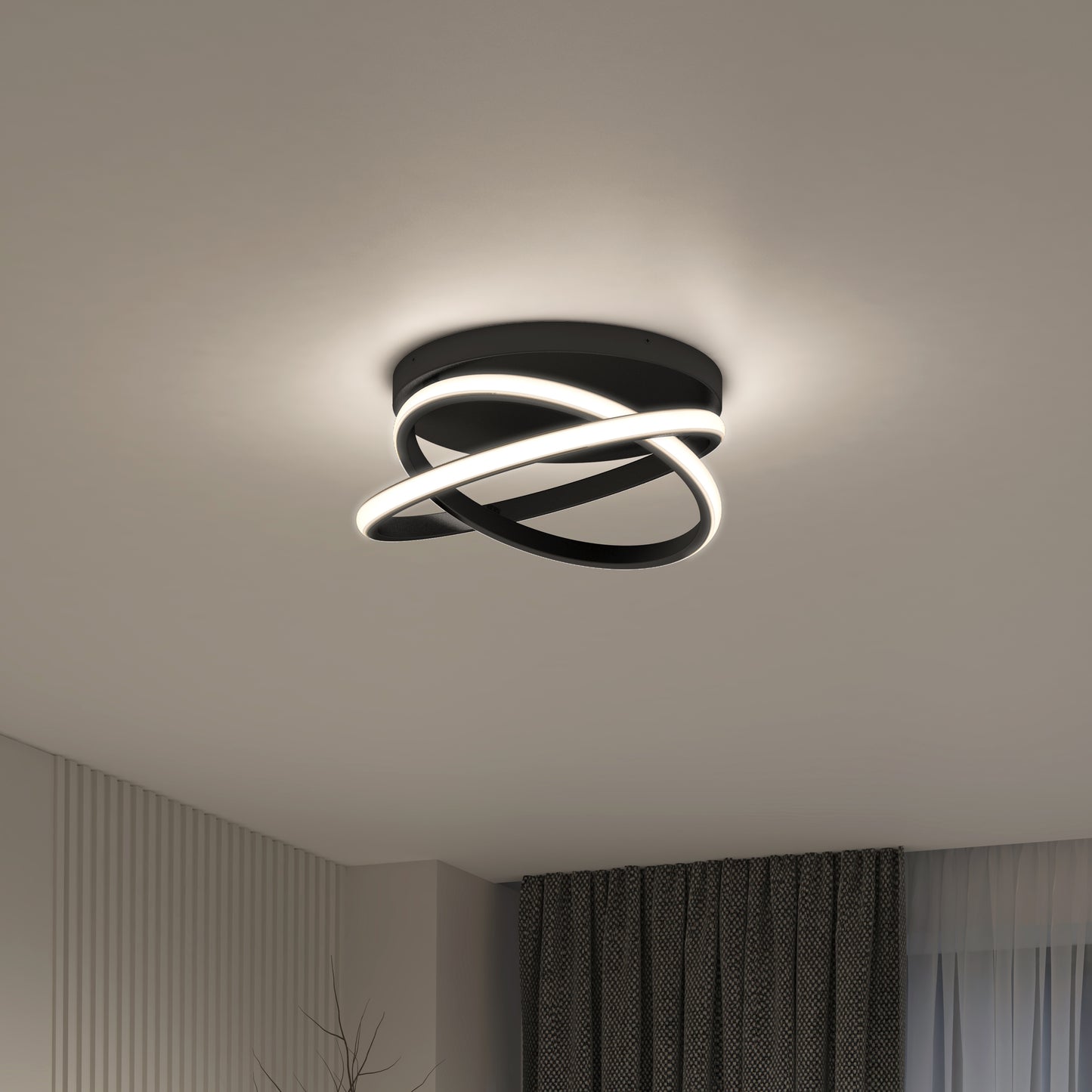 The Artika Orbia modern LED flush mount light 3 CCT features intertwined black rings with built-in LEDs, shown mounted on a white ceiling in a contemporary room with striped white walls and dark curtains.