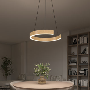 A modern dining room features the Artika Vance modern LED pendant light 3 CCT hanging above a round table with a potted plant, a bookshelf in the background, and a sofa with a large leafy plant in the corner.