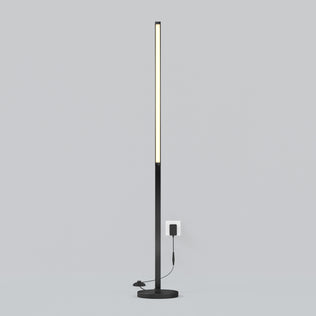 The Artika Arc LED Floor Lamp is a slim, modern black dimmable floor lamp with a vertical LED strip on a round base, shown plugged into a wall outlet against a plain light gray background.
