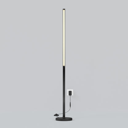 The Artika Arc LED Floor Lamp is a slim, modern black dimmable floor lamp with a vertical LED strip on a round base, shown plugged into a wall outlet against a plain light gray background.