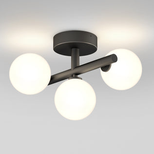 The Artika Bloom LED flush mount features three glowing white glass globes on a black base, mounted on a white ceiling.