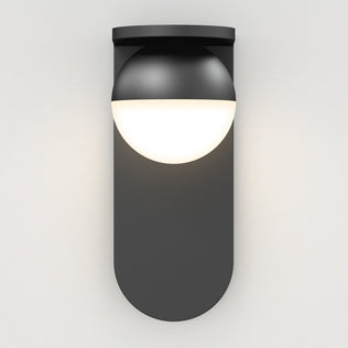 The Artika Bloom indoor-outdoor LED wall light 3 CCT features a modern black design with a rounded base and half-sphere white diffuser, casting a soft, diffused glow on any plain white wall.