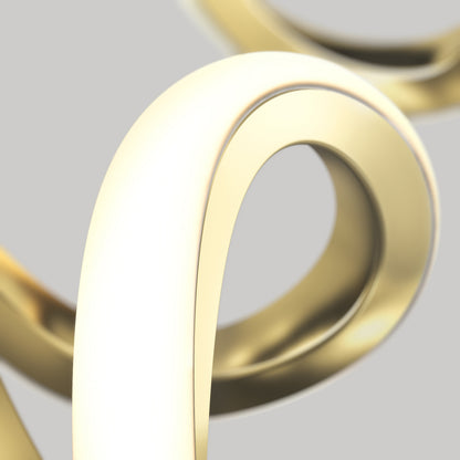 A close-up of smooth, intertwined, shiny gold loops set against a light gray background. The image highlights the curves and reflective surface of the metallic shapes.