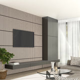A modern living room with a wall-mounted TV, vertical wood slat accent wall, floating dark cabinets, a round glass coffee table, a gray sofa, sheer curtains, and a potted plant.