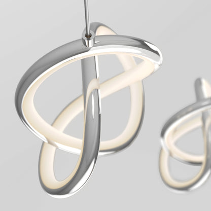 The Artika Zephyr 3-light LED pendant features intertwined metallic loops and integrated dimmable soft white light, creating a modern sculptural look when suspended from the ceiling against a neutral background.