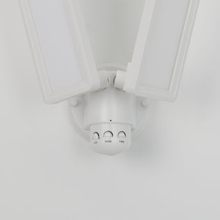 The Artika Sentinel outdoor Flat Panel Security light is a white LED floodlight with two adjustable rectangular panels and three control dials (LUX, SENS, TIME), mounted on a white wall.