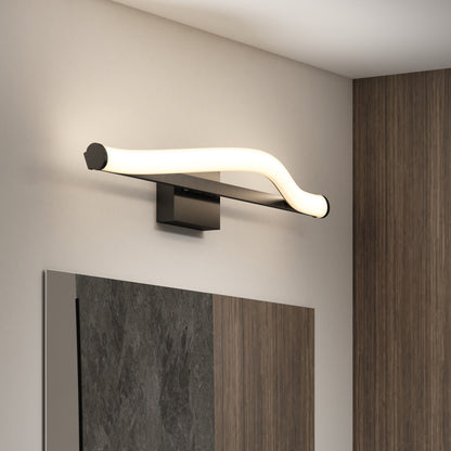 The Artika Arc modern LED bathroom vanity light 5 CCT, featuring a wave-shaped design, is wall-mounted above a large mirror on a white and wood-accented wall.