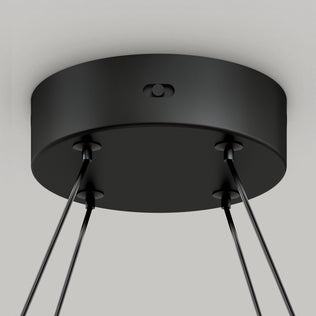 Close-up view of Artikas Atrium LED pendant light 5CCT, featuring a modern round black ceiling canopy with multiple attached cables, designed for stylish chandelier lighting.