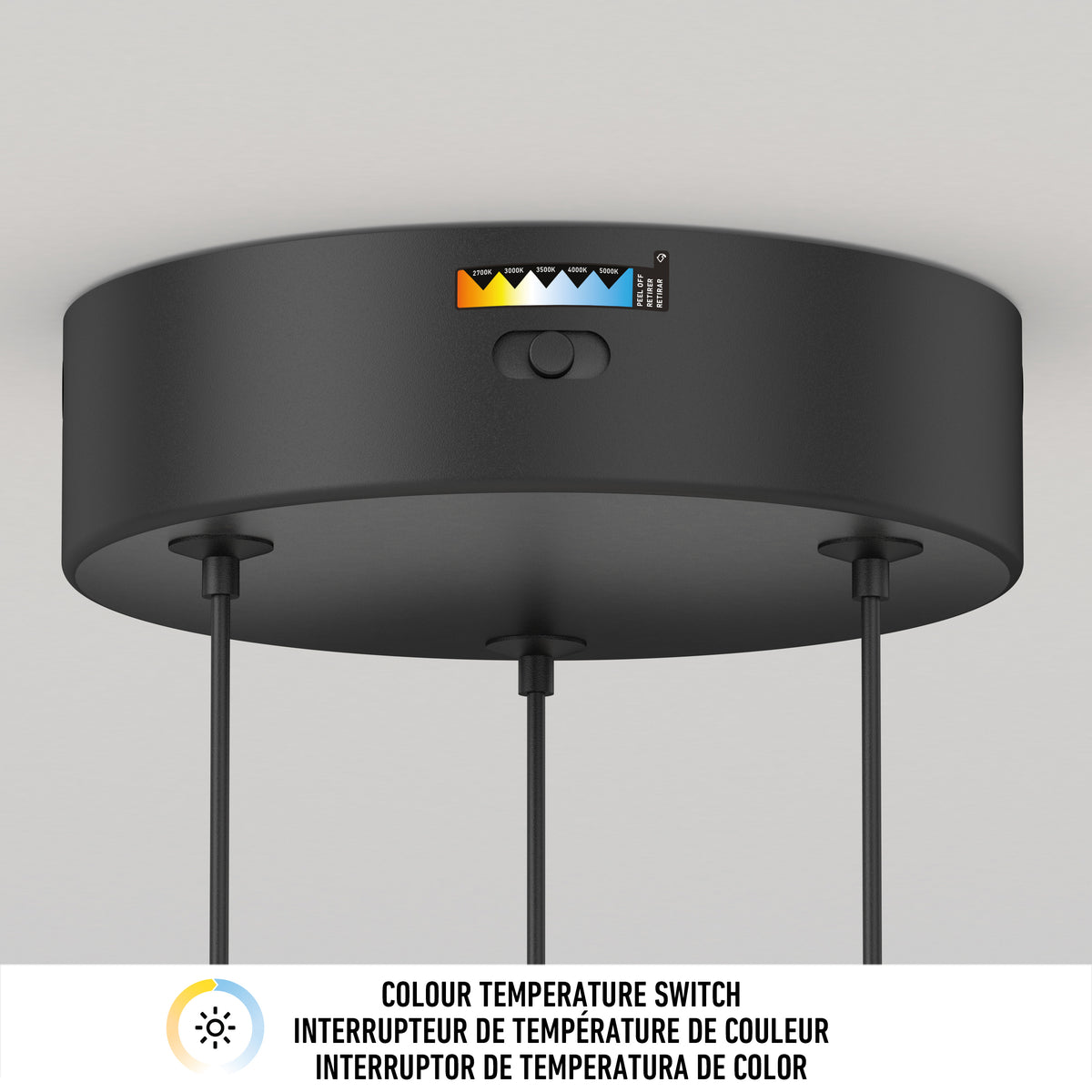 A close-up of Artika’s Bolero LED pendant light 5 CCT, a black ceiling-mounted fixture with a color temperature switch and indicator showing multiple warmth options. Three cords hang below. "Colour Temperature Switch" appears in English and French.