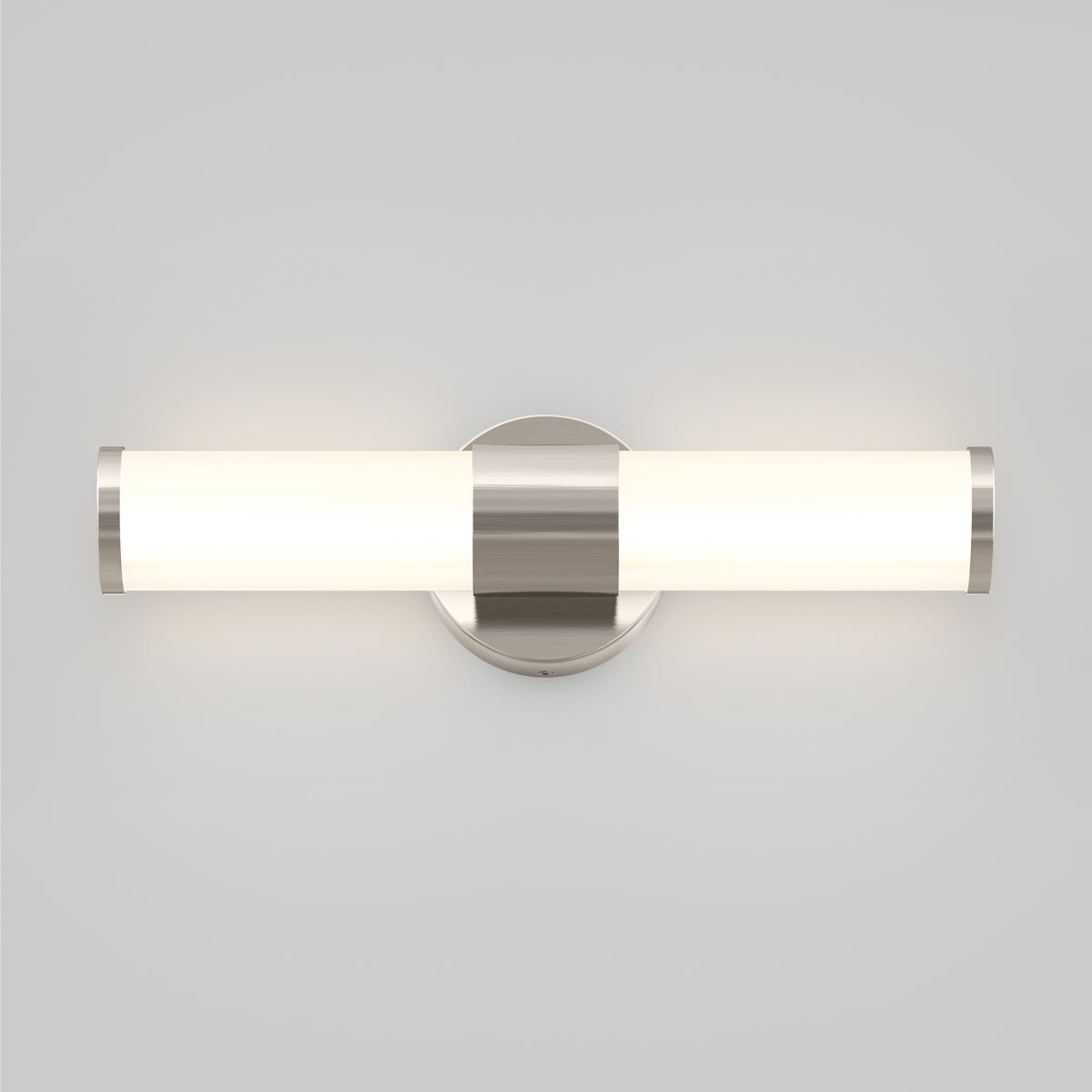 A modern wall-mounted light fixture with a cylindrical frosted glass shade and metallic accents, emitting a soft, even glow against a plain light gray wall.