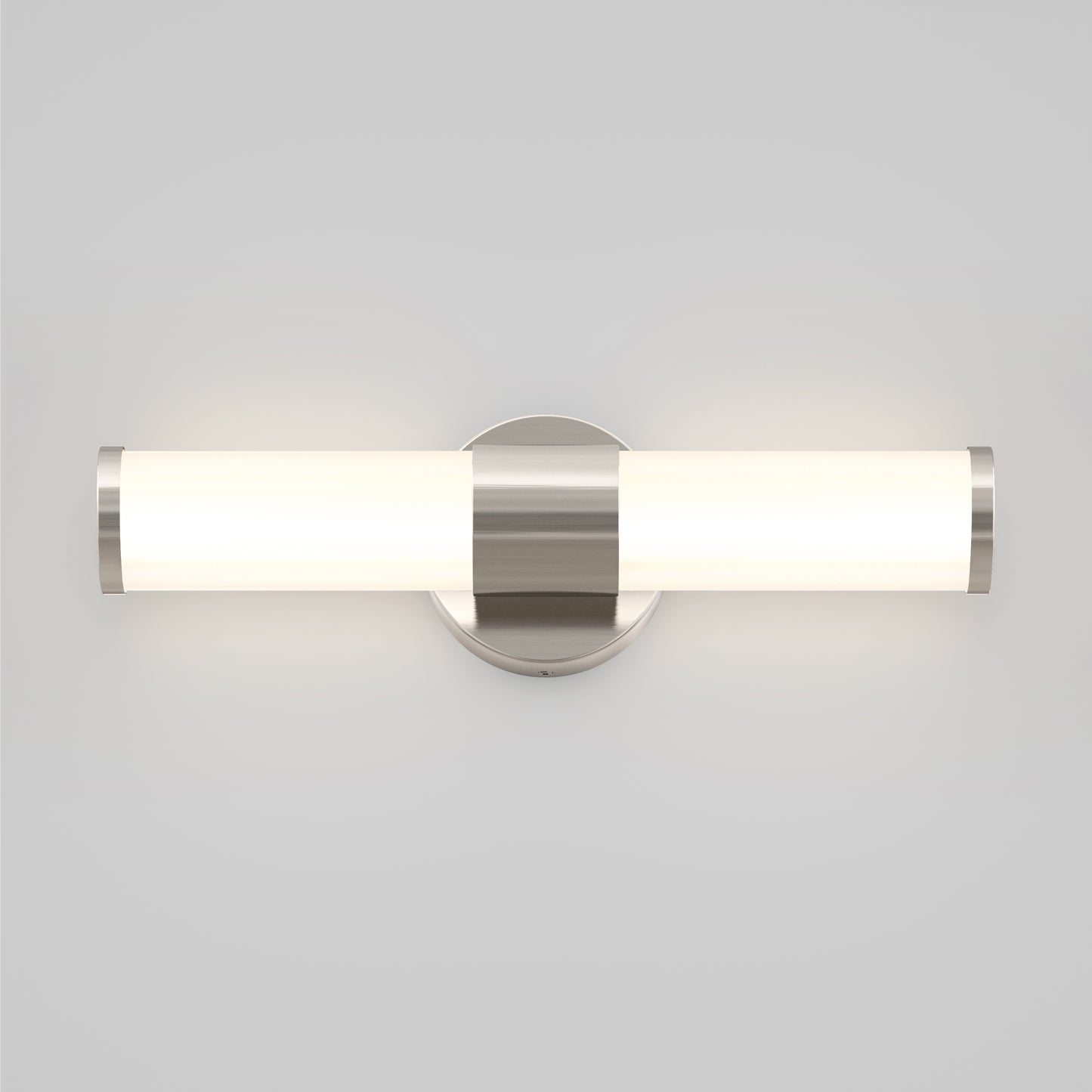 The Artika Adina modern bathroom vanity light 3 CCT features a cylindrical frosted glass shade and brushed metal accents, casting a soft glow against a light gray wall.