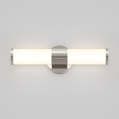 The Artika Adina modern bathroom vanity light 3 CCT features a cylindrical frosted glass shade and brushed metal accents, casting a soft glow against a light gray wall.