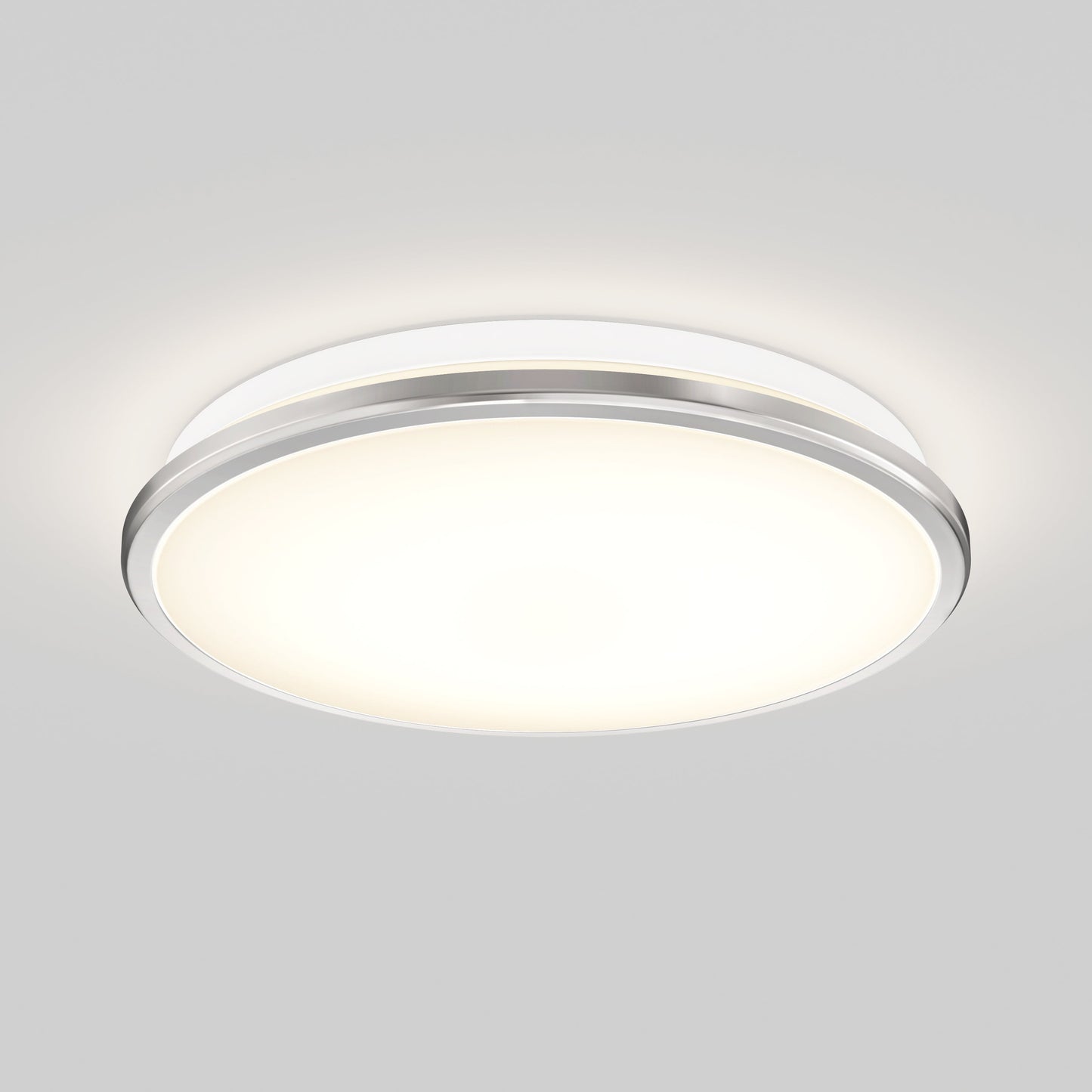 The Artika-CAN-dev Vera 13 in. LED modern flush mount light features a round frosted white cover, slim silver rim, LED dimmer compatibility, and emits a soft, even glow when mounted on a plain white ceiling.