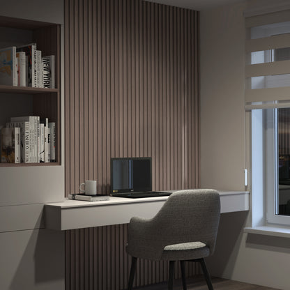 A modern home office with a gray upholstered chair at a white desk, featuring Artikas Panolok 30.67 ft wall panel kit (pack of 8) on the wall, plus a closed laptop, mug, and books by a window with striped blinds.