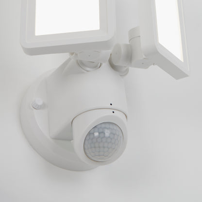 A close-up of the Artika Sentinel outdoor Flat Panel Security light, featuring two rectangular LED panels and a round motion sensor, mounted on a white wall.