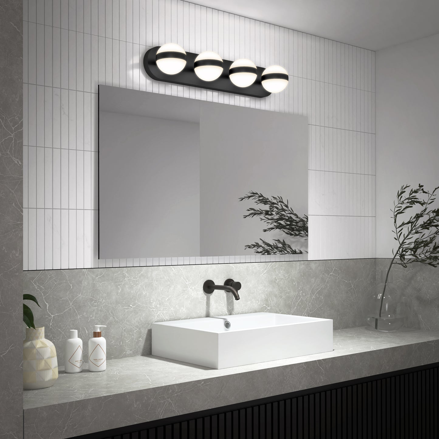 Modern bathroom with a large rectangular mirror, white vessel sink, matte black faucet, and the Artika Baldric LED modern bathroom vanity light 3 CCT. Minimalist decor includes two bottles, a vase, and a leafy branch on a gray countertop.