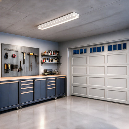 An Artika Aiden 48 in. x 6 in. Modern Ceiling Light 5 CCT LED flush mount fixture installed in a garage workshop.