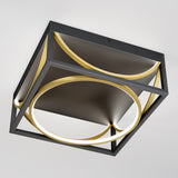 A modern ceiling light with a square black frame and two illuminated gold circular rings, mounted on a white ceiling. The design is geometric and contemporary.