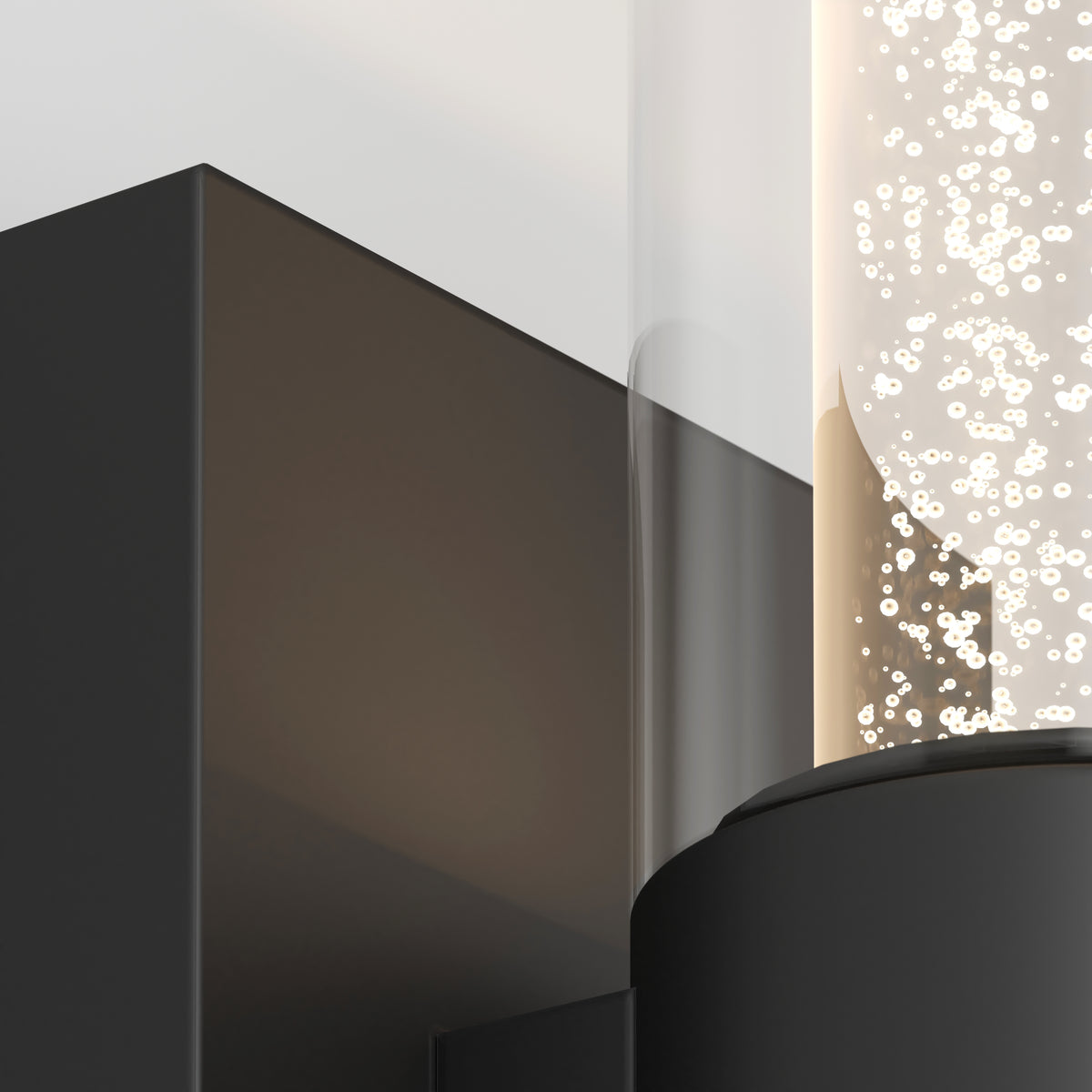 Close-up of a modern wall-mounted light fixture with a rectangular black base and a cylindrical glass tube filled with small, glowing bubbles or particles.